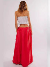 Load image into Gallery viewer, Woman wearing Boho maxi skirt with side bow tie and pockets in red. Rear view - Gypsy Collection women's skirt