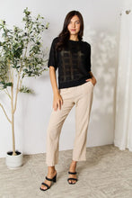 Load image into Gallery viewer, Women&#39;s ribbed knit half sleeve top with round neckline with sheer style. Features a see-through design with solid rectangular fabric detailing. Allows visibility of bralette. On model front view of top beige high-waisted pants and heels - Valerie Collection Mandy top
