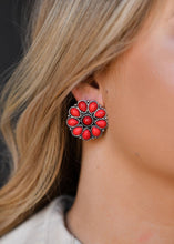 Load image into Gallery viewer, Burnished silver and red flower stud earrings. Spice up your look with these red chile color, western style earrings - Close up on model. Western style. Red earrings. Statement Earrings for women. The Jolene Collection - Lucky Birds Boutique
