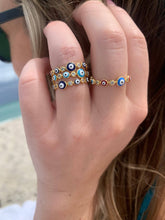 Load image into Gallery viewer, Evil Eye 🧿 dark blue iris with gold band rings stacked on model: Ward Off Evil from your life with this easy to wear Evil Eye Ring. The eye protects it’s wearer from jealousy, bad luck and ill wishes from others. Jewelry gift. Boho Jewelry. Evil eye ring. Evil eye jewelry. The Gypsy Collection - Lucky Birds Boutique 
